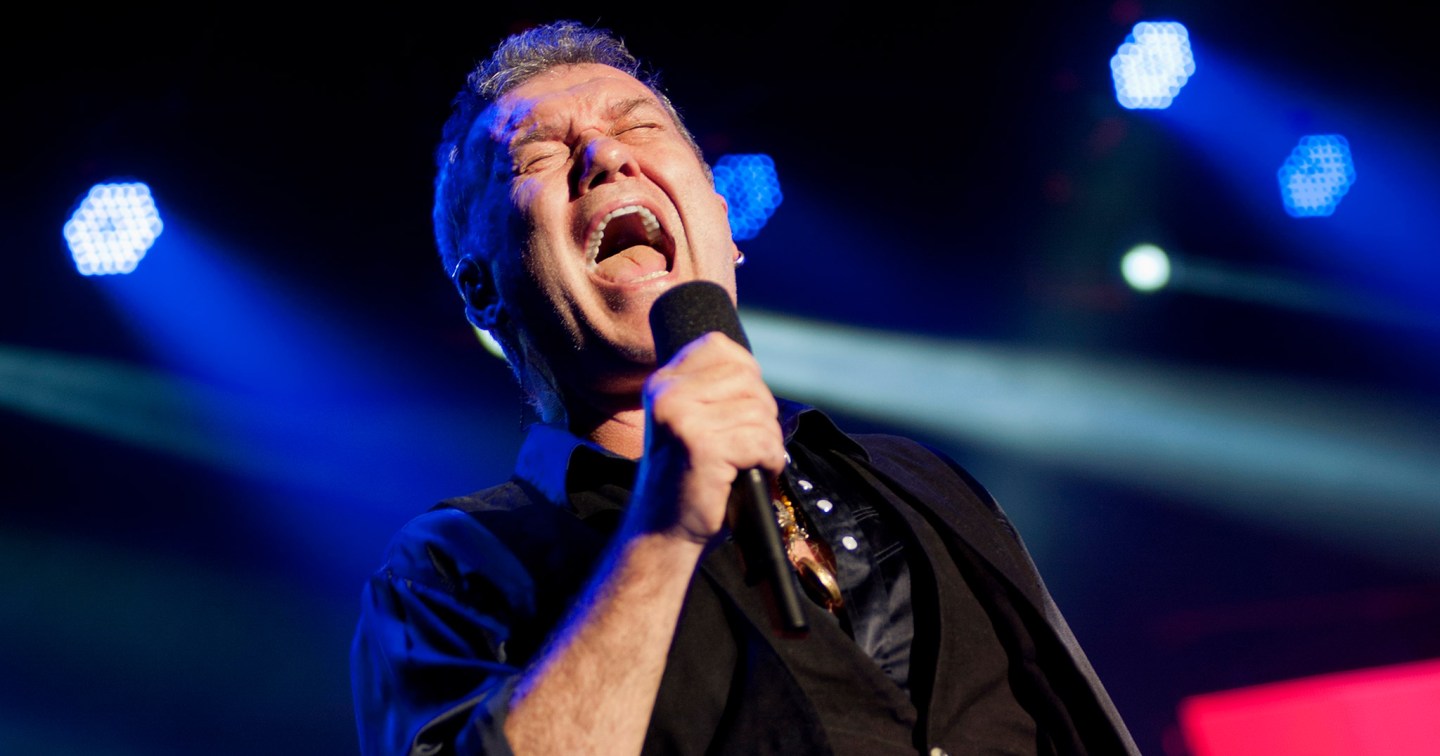 Jimmy Barnes singing into a microphone during a concert